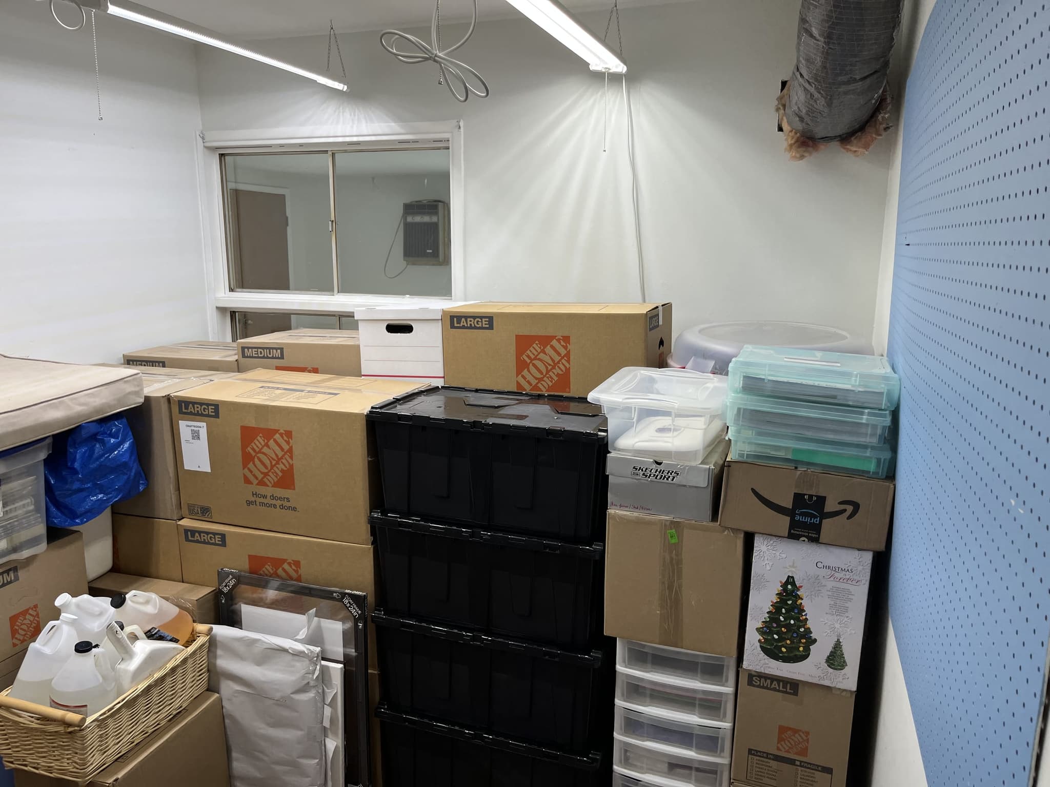 Same storage room with everything boxed and stacked along the wall, floor cleared, after pack-up
